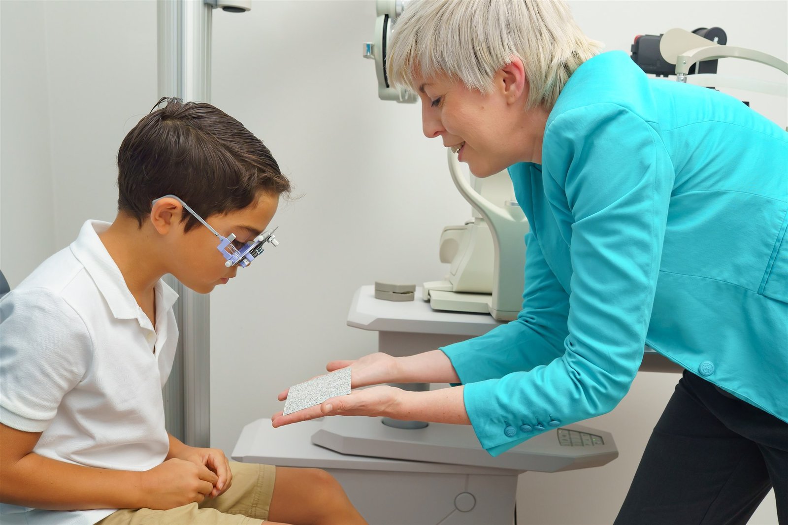 Kindvriendelijke optometrist voert een oogtest uit bij een kind