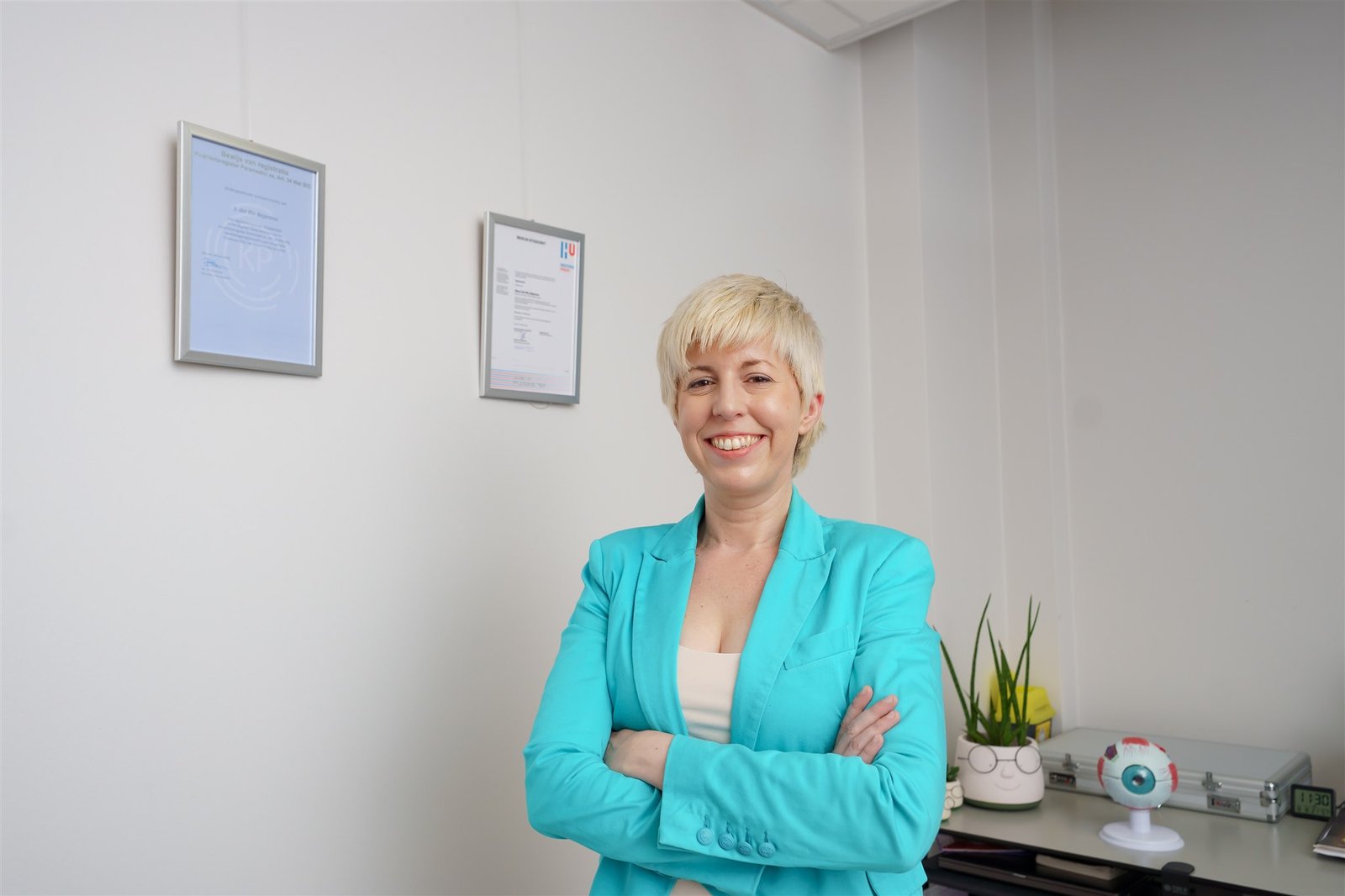 De optometrist van Zeker Zicht met diploma's op de achtergrond.